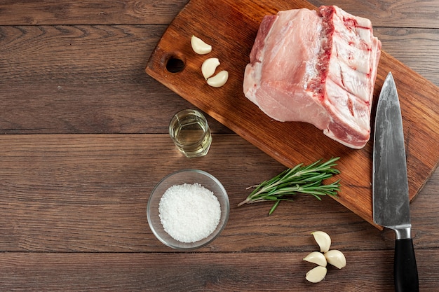 Steak de bifteck frais de viande crue et d'épices et un couteau se trouve sur le bois.