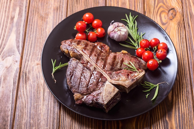 Steak de bœuf d'aloyau grillé avec tomates et ail