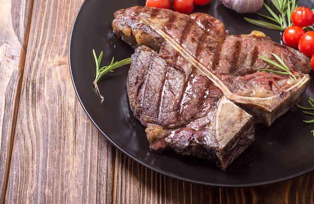 Steak de bœuf d'aloyau grillé avec tomates et ail