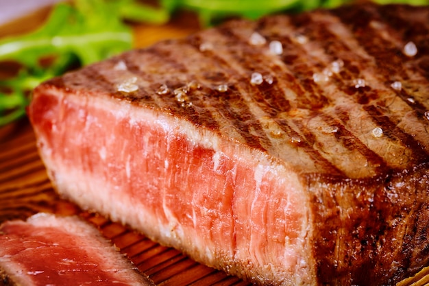 Steak de boeuf angus rare grillé sur planche de bois.