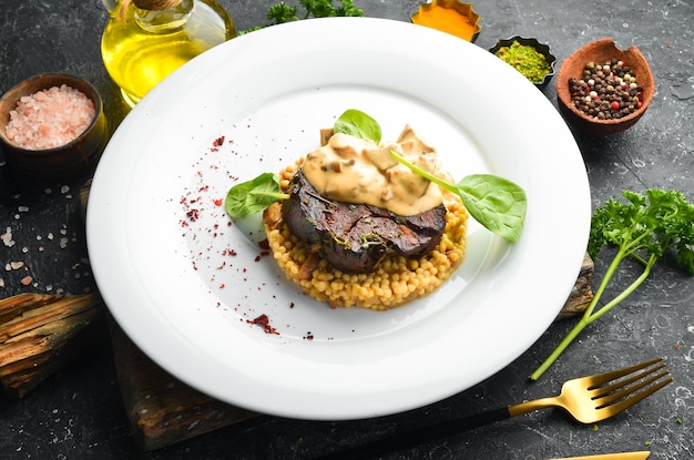 Steak de boeuf au boulgour et champignons sur une assiette Menu du restaurant Cuisine européenne