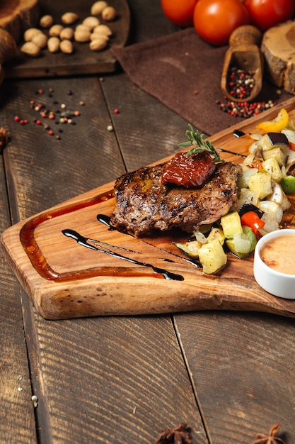 Steak de boeuf aux légumes sur la planche de bois