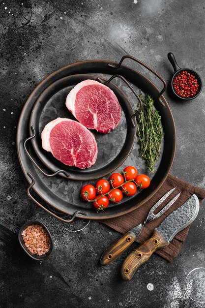 Steak de boeuf biologique cru frais sur fond de table en pierre noire vue de dessus à plat