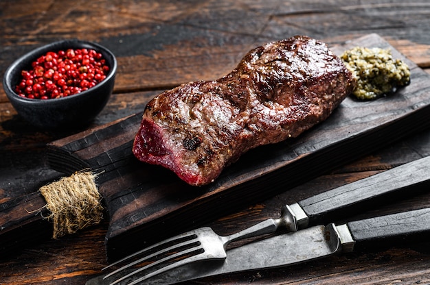 Steak de bœuf black angus marbré grillé. Fond en bois. Vue de dessus.