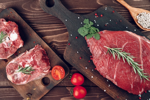 Steak de boeuf cru au romarin et épices sur planche de bois