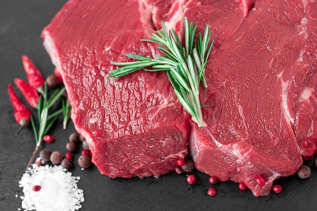 Steak de boeuf cru aux épices sur une planche sombre