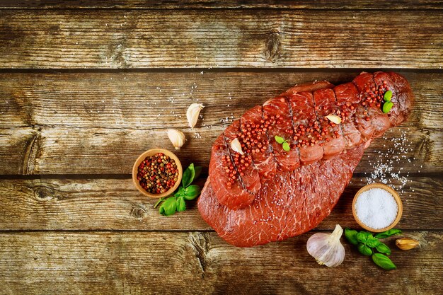 Steak de boeuf cru aux épices sur une table en bois