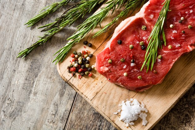 Steak de boeuf cru épicé prêt à cuire sur table en bois Vue de dessus Copyspace