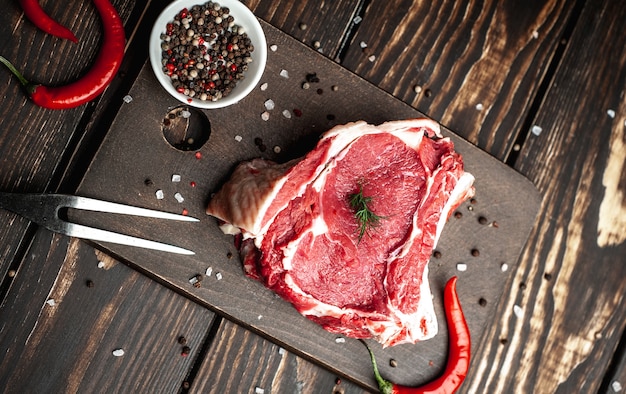 Photo steak de boeuf cru frais sur une planche à découper en bois