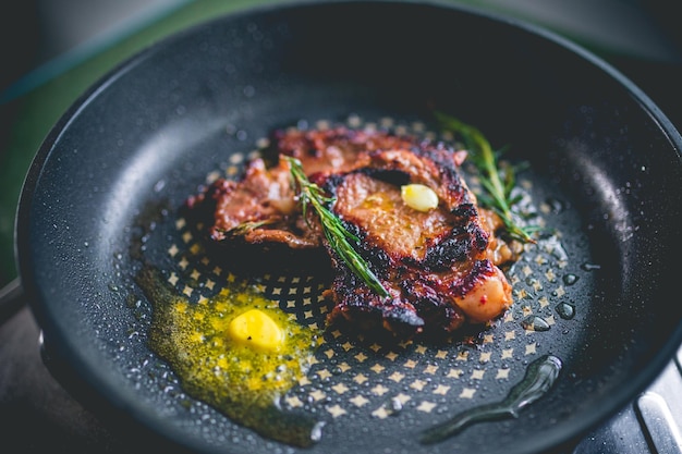 Steak de boeuf cuit au romarin et à l'ail dans une poêle en fer