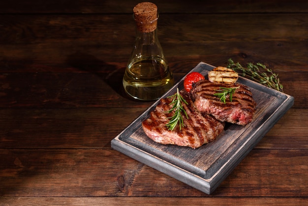 Steak de boeuf délicieux juteux frais sur un fond sombre. Plat de viande aux épices et herbes