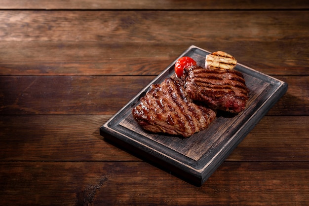 Steak de boeuf délicieux juteux frais sur tableau noir. Plat de viande aux épices et herbes