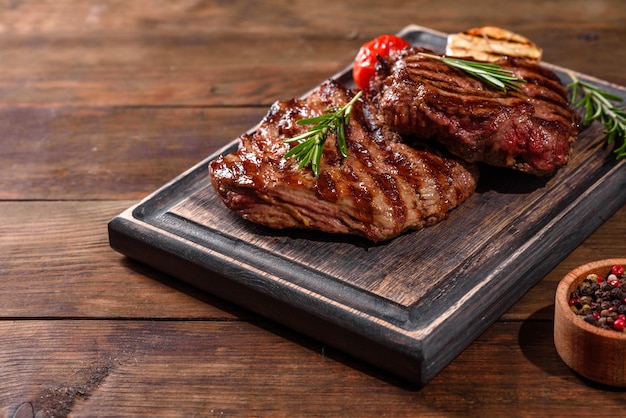 Steak de boeuf délicieux juteux frais sur tableau noir. Plat de viande aux épices et herbes