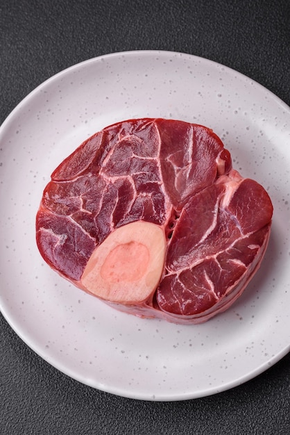 Steak de bœuf frais cru avec des os ou ossobuco avec des épices salées et des herbes