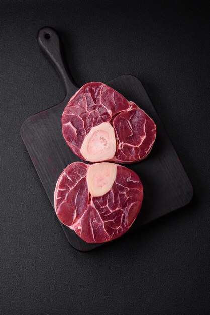 Steak de bœuf frais cru avec des os ou ossobuco avec des épices salées et des herbes