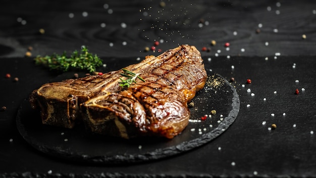 Steak de bœuf grillé au T-bone. Steak Porterhouse au barbecue vieilli à sec. Moyennement rare. Cuisine américaine. Format de bannière longue, vue de dessus.