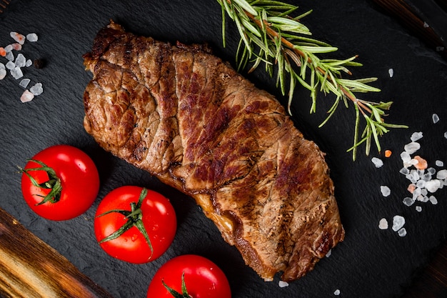 Steak de boeuf grillé aux épices sur fond noir