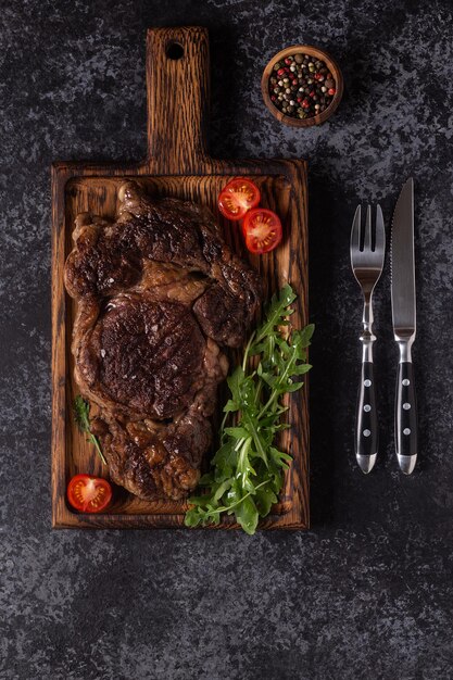 Steak de boeuf grillé aux épices sur une vue de dessus de planche de bois