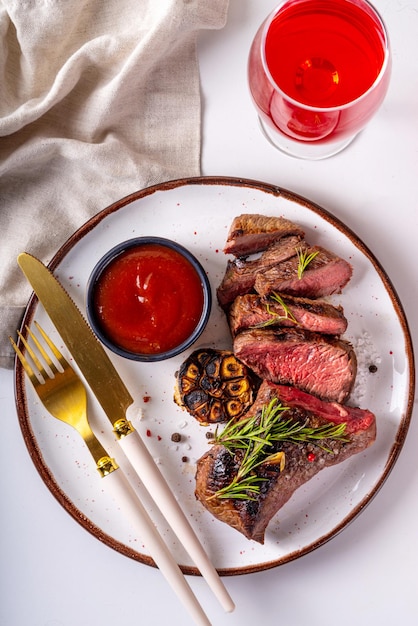 Steak de bœuf grillé aux herbes et épices Portion de morceaux de viande frits avec huile d'olive à l'ail et au romarin et sauce ketchup