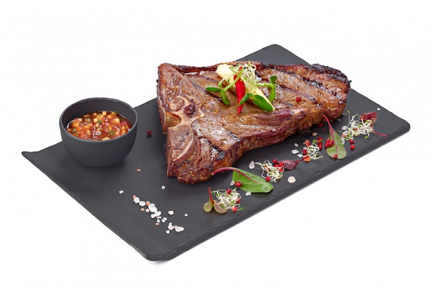 Steak de boeuf grillé sur plaque grise isolated on white