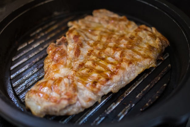 Steak de boeuf grillé sur la poêle noire. Délicieux steak maison assaisonné avec du sel et du poivre.