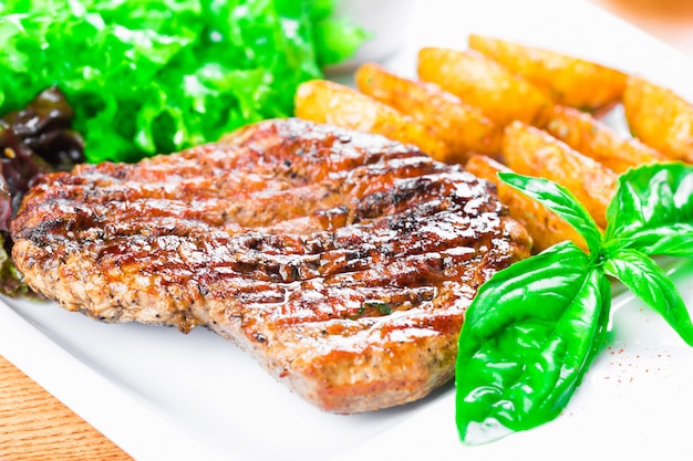 Steak de bœuf grillé avec des quartiers de pomme de terre se bouchent