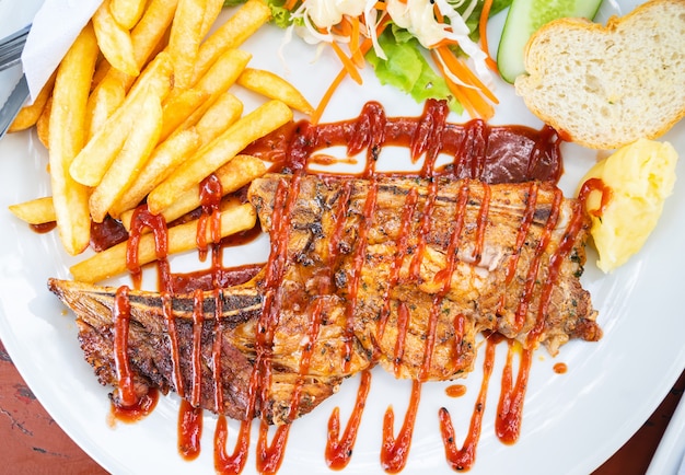 Steak de boeuf grillé avec salade sur une assiette