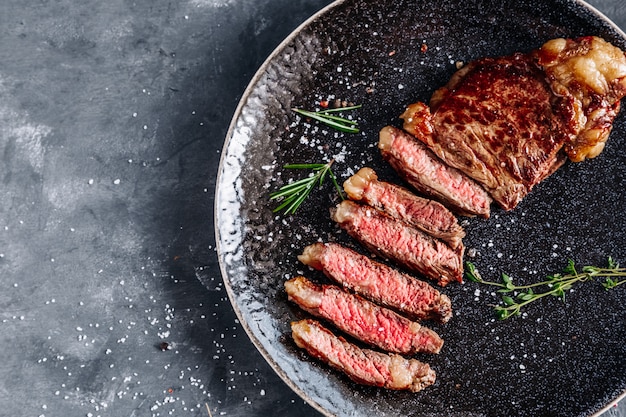 Steak de boeuf grillé en tranches avec vue de dessus de romarin