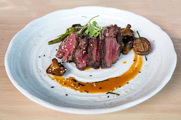 Steak de bœuf japonais Kobe aux champignons, échalote et sauce ponzu sur un plateau