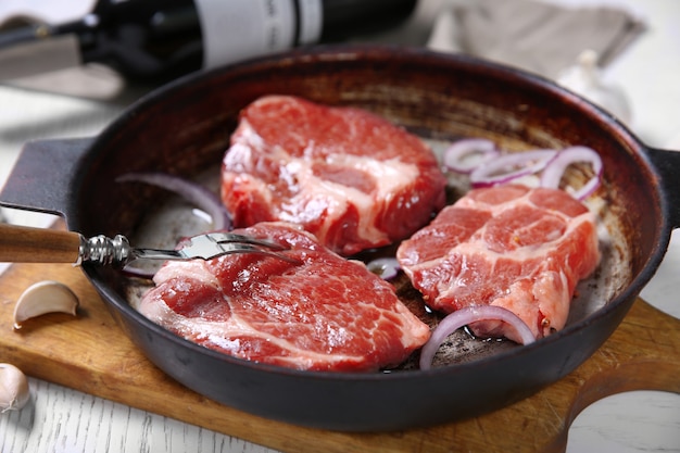 Steak de boeuf marbré et bouteille de vin sur fond de bois