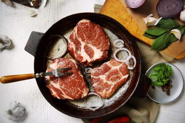 Steak de boeuf marbré sur poêle et épices sur bois de couleur