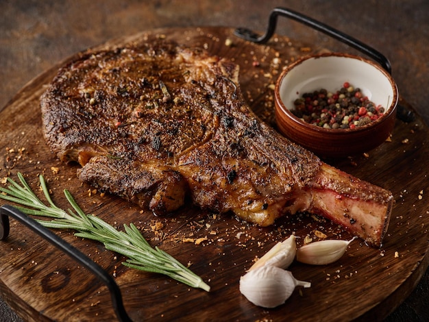 Steak de boeuf en marbre séché Tomahawk sur planche de bois avec des épices