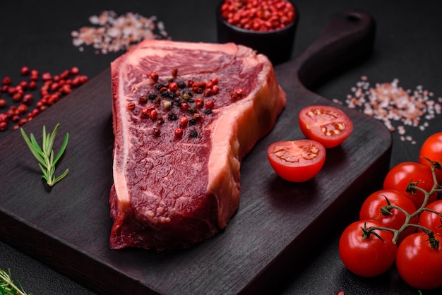 Steak de boeuf new york cru juteux frais avec des épices et des herbes salées