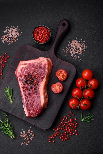 Steak de boeuf new york cru juteux frais avec des épices et des herbes salées