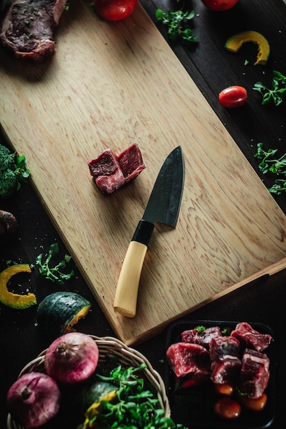 steak de bœuf sur une planche à découper avec un couteau et des ingrédients