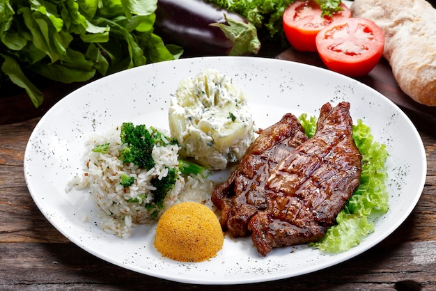 Steak de boeuf avec pommes de terre et riz en fond blanc isolé