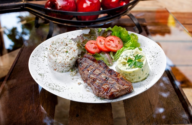 Steak de boeuf avec pommes de terre et riz en fond blanc isolé