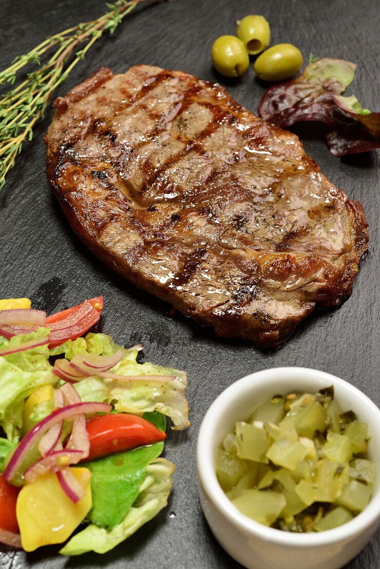 Steak de boeuf avec salade sur une plaque en ardoise
