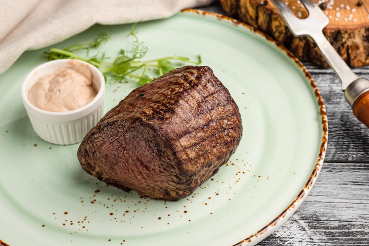 Photo steak de boeuf steak de boeuf grillé sur un fond blanc en bois
