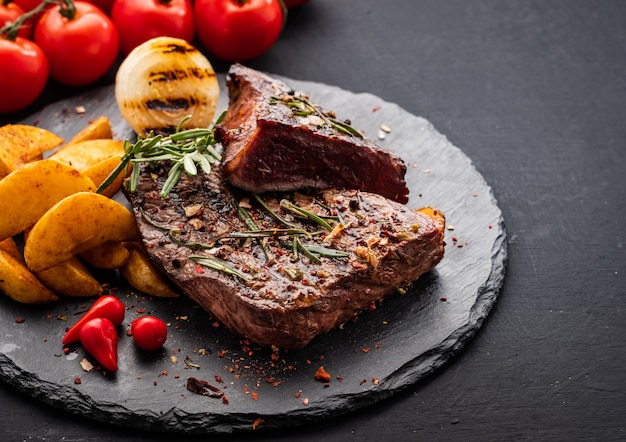 Photo steak de boeuf. steak de boeuf moyen au poivron rouge, herbes aromatiques et oignon frit