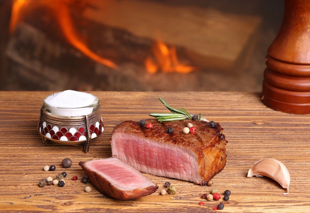 Steak de boeuf sur une table en bois sur fond de feu