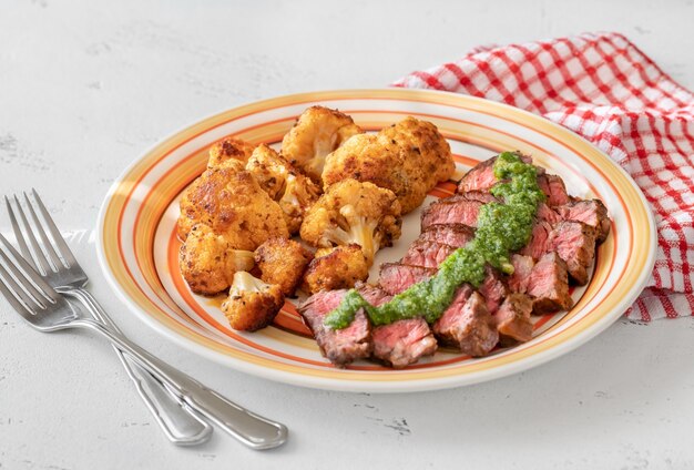 Steak de boeuf tranché garni de fleurons de chou-fleur cuits au four