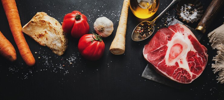Steak de boeuf à la viande crue avec os et légumes épices sur une surface sombre