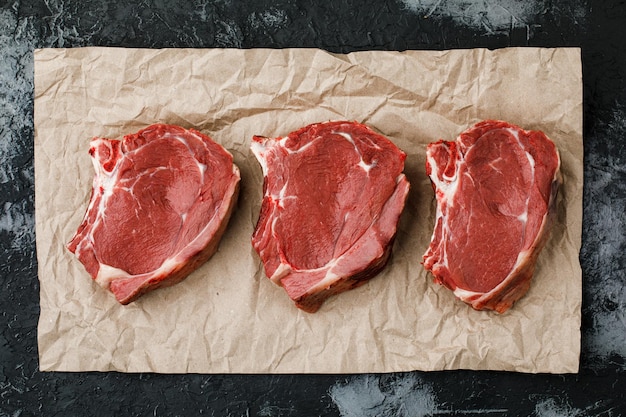 Steak de boeuf de viande fraîche crue sur une vue de dessus de fond noir