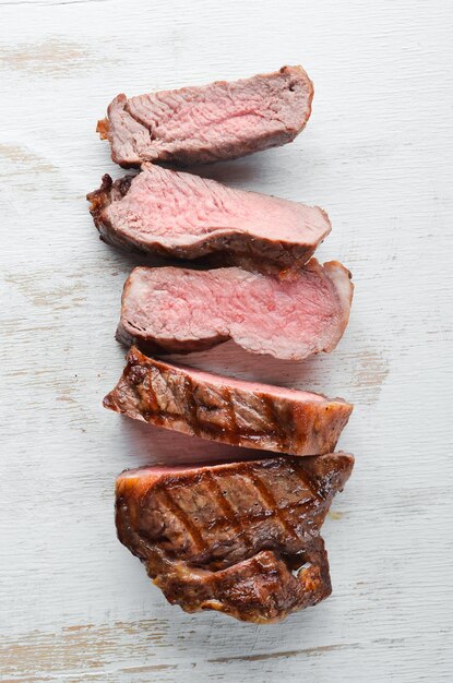 Steak de boeuf Viande de veau Sur un fond en bois blanc Vue de dessus Espace de copie gratuit