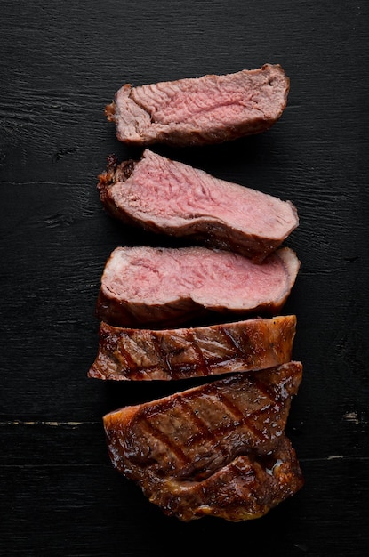 Steak de boeuf Viande de veau Sur un fond en bois noir Vue de dessus Espace de copie gratuit