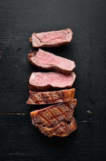 Steak de boeuf Viande de veau Sur un fond en bois noir Vue de dessus Espace de copie gratuit