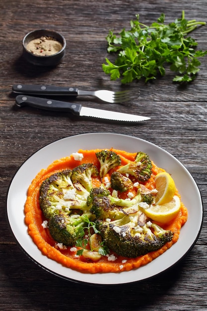 Steak de brocoli grillé avec purée de citrouille garnie de fromage feta émietté, recette végétarienne, vue verticale d'en haut