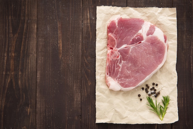 Steak de côtelette de porc cru sur table en bois