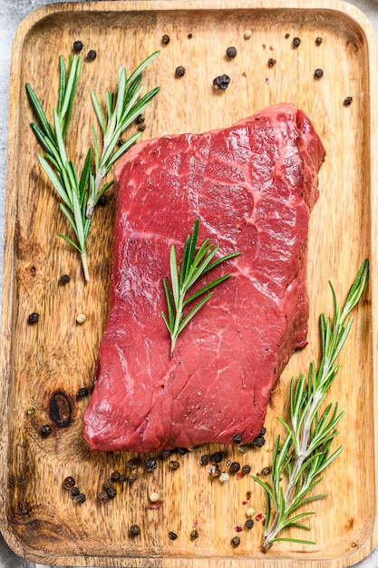 Steak de croupe cru sur un plateau en bois. Viande de boeuf. Vue de dessus.